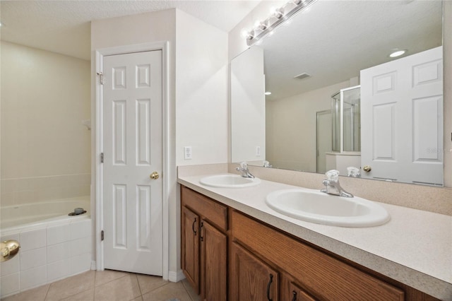 bathroom featuring tile patterned floors, vanity, a textured ceiling, and shower with separate bathtub