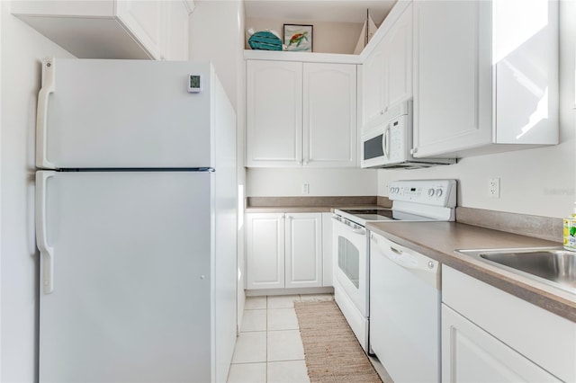 kitchen with white cabinets, light tile patterned flooring, and white appliances