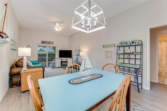 dining room with light wood-type flooring and ceiling fan with notable chandelier