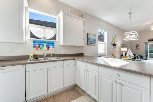 kitchen featuring white cabinetry, decorative light fixtures, white dishwasher, sink, and kitchen peninsula