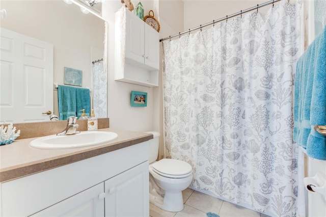 bathroom with toilet, vanity, and tile patterned flooring