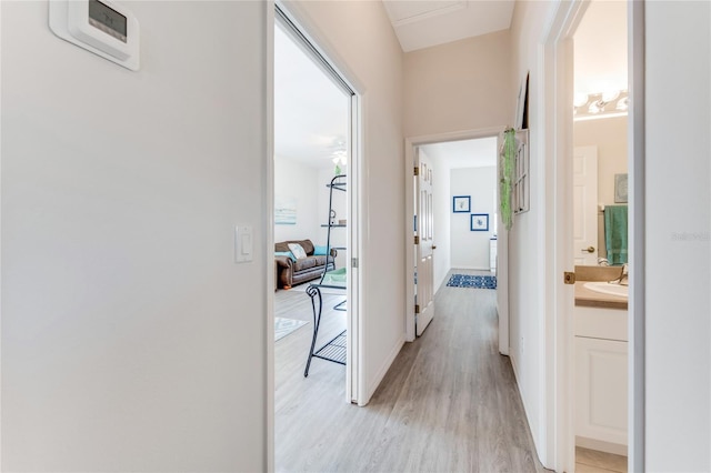 hall with sink and light wood-type flooring