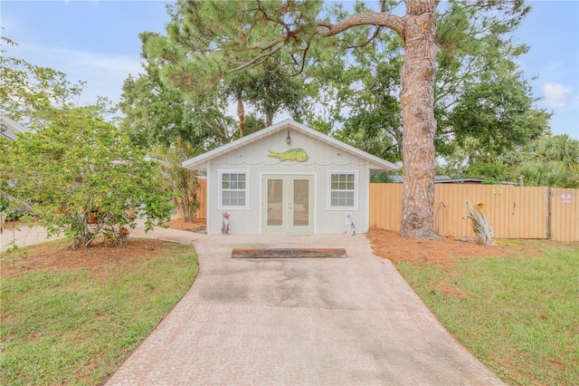 view of outdoor structure with french doors and a lawn