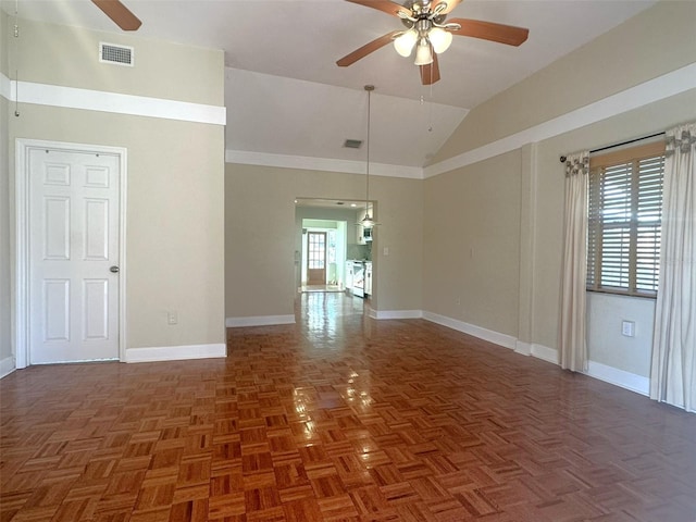 spare room featuring vaulted ceiling, dark parquet floors, and ceiling fan