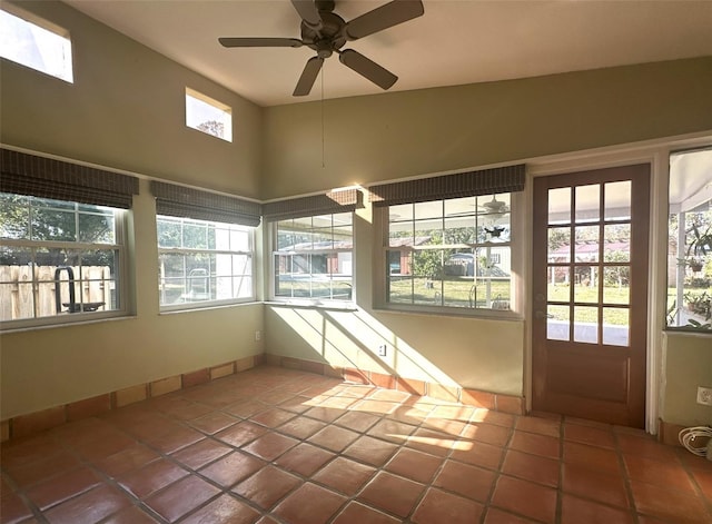 unfurnished sunroom featuring ceiling fan