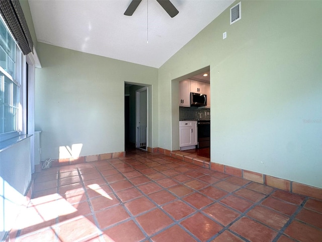 tiled empty room with high vaulted ceiling and ceiling fan