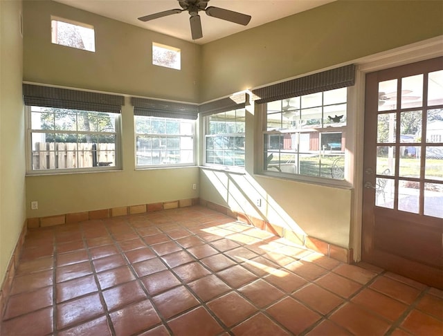 unfurnished sunroom featuring ceiling fan