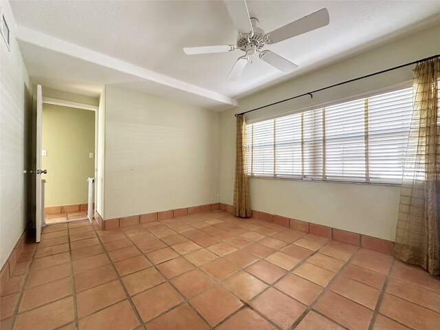 tiled spare room with ceiling fan