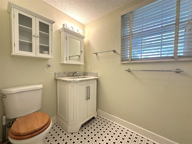 bathroom featuring vanity, a textured ceiling, and toilet