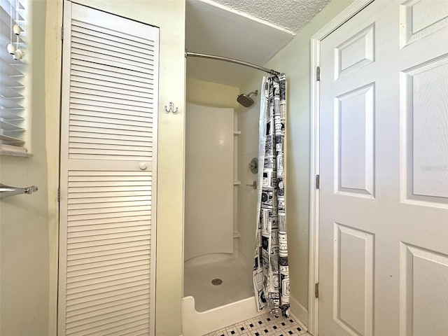 bathroom with a textured ceiling and a shower with shower curtain