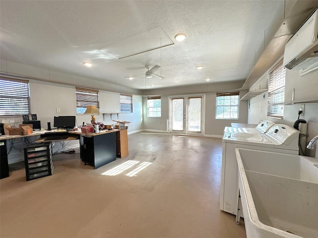 interior space featuring sink, white cabinetry, a textured ceiling, separate washer and dryer, and concrete floors