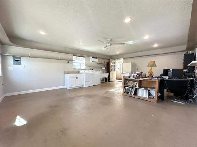 garage with ceiling fan, an AC wall unit, and washing machine and clothes dryer