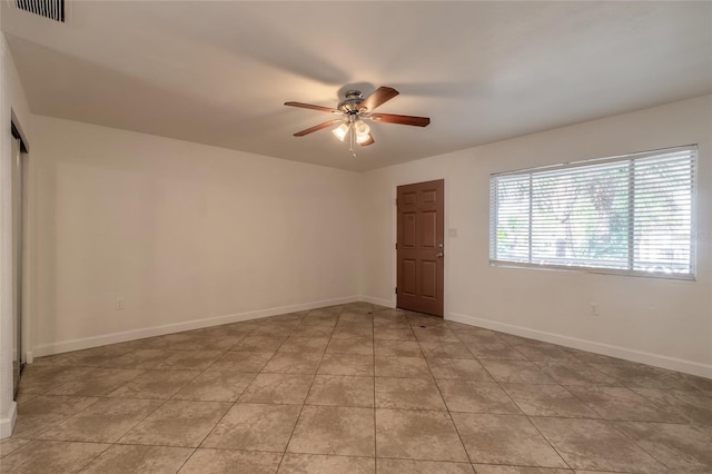 empty room with ceiling fan and light tile patterned flooring