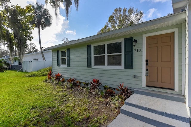 view of exterior entry with a yard