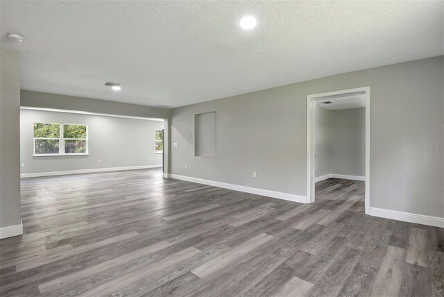 empty room featuring a textured ceiling and hardwood / wood-style flooring