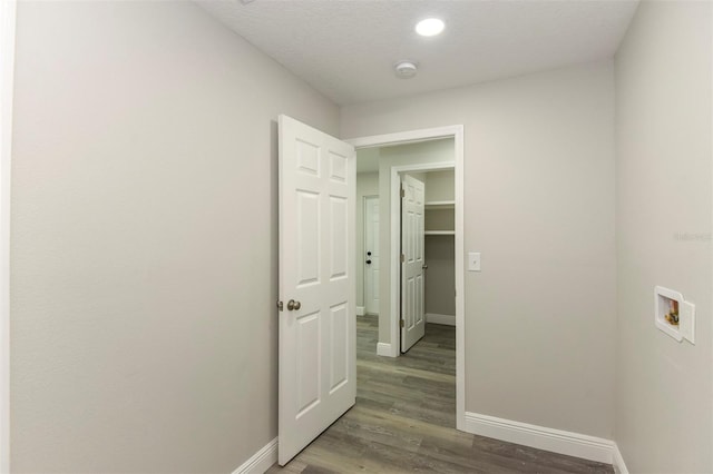 hall featuring dark wood-type flooring and a textured ceiling