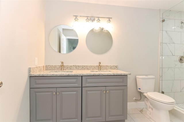 bathroom with vanity, toilet, and tiled shower