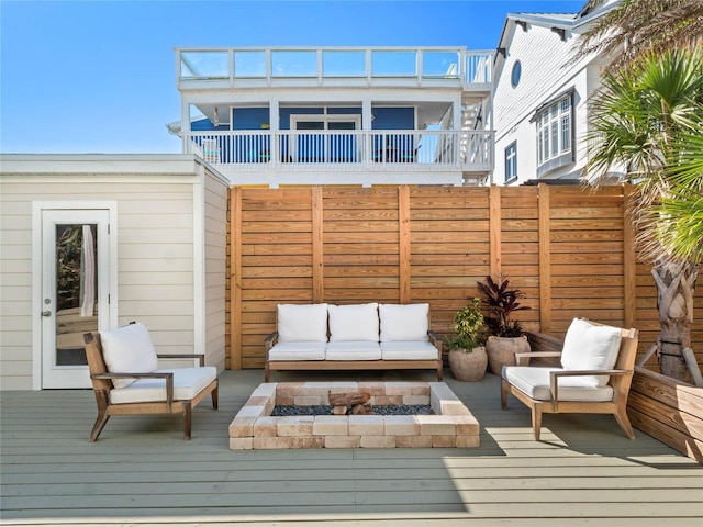 wooden deck featuring an outdoor living space with a fire pit