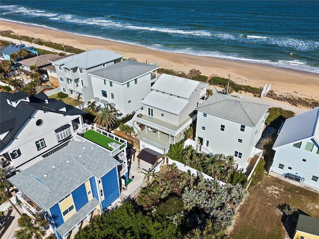 birds eye view of property featuring a water view and a beach view