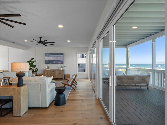 living room featuring light wood-type flooring and ceiling fan