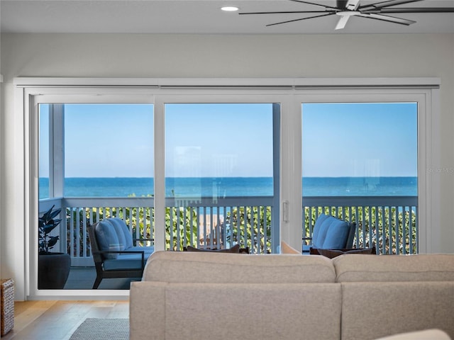 living room with a healthy amount of sunlight, a water view, and light hardwood / wood-style floors