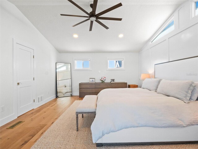 bedroom with light hardwood / wood-style floors, ceiling fan, and vaulted ceiling