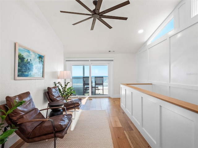 sitting room featuring light hardwood / wood-style floors, ceiling fan, and vaulted ceiling