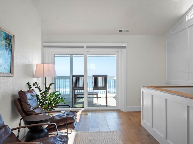 sitting room featuring light hardwood / wood-style flooring and lofted ceiling