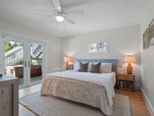 bedroom with light hardwood / wood-style floors, multiple windows, ceiling fan, and access to outside