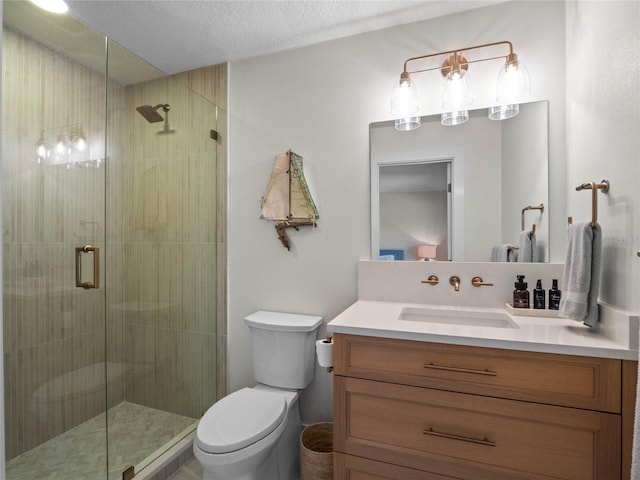 bathroom featuring vanity, toilet, a textured ceiling, and an enclosed shower