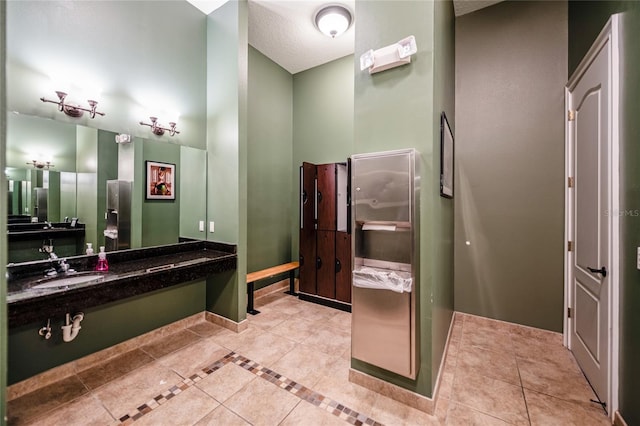 bathroom with tile patterned floors, sink, and a textured ceiling