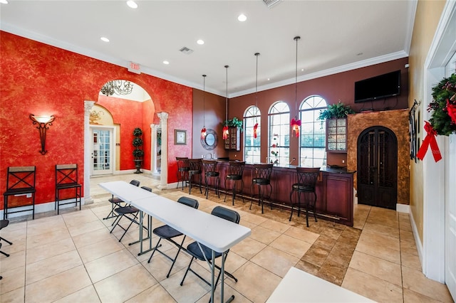 interior space with light tile patterned floors, decorative light fixtures, and ornamental molding