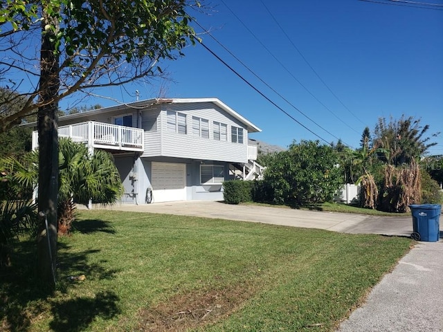 view of property exterior featuring a garage, a yard, and a balcony