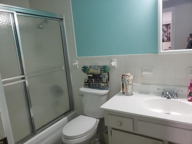 bathroom with vanity, toilet, and tile walls