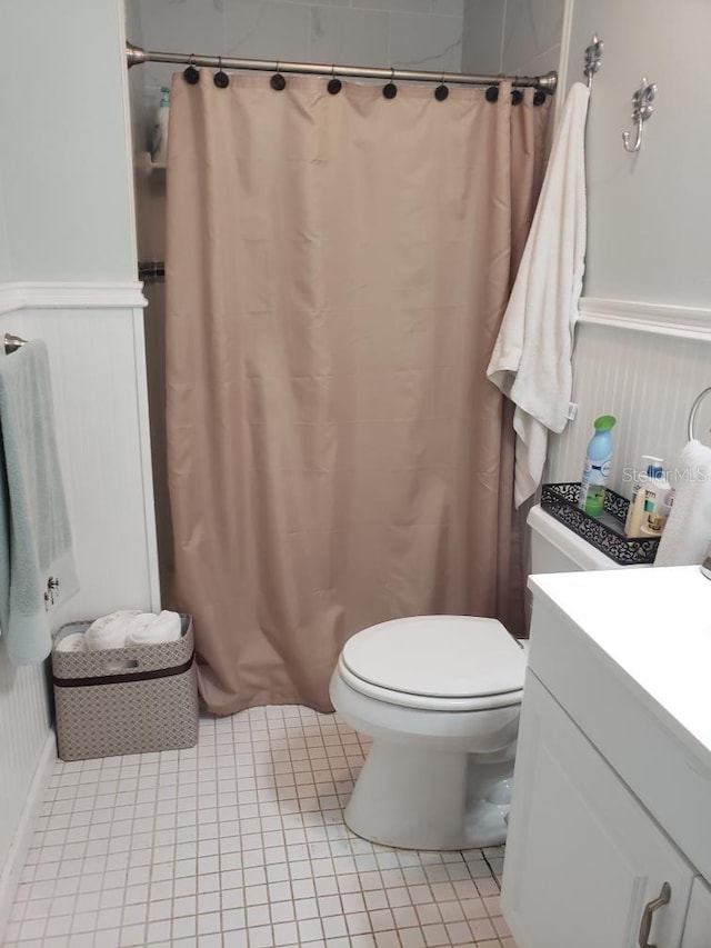 bathroom featuring a shower with shower curtain, tile patterned floors, vanity, and toilet