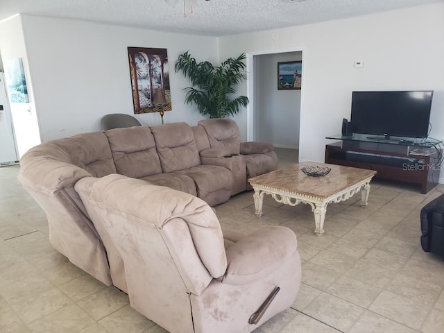 living room with a textured ceiling and ceiling fan