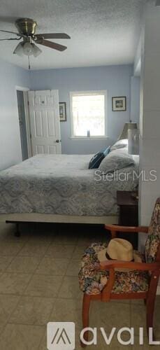 tiled bedroom with ceiling fan