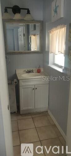 824 Garfish Ave, New Smyrna Beach, FL 32169 - bathroom with tile patterned flooring, vanity, and baseboards