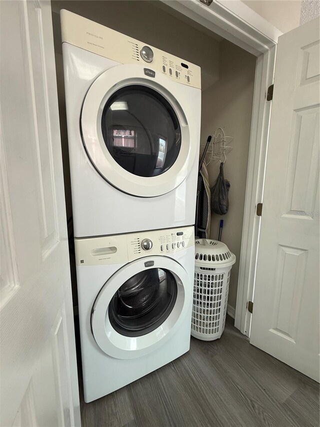 824 Garfish Ave, New Smyrna Beach, FL 32169 - laundry room featuring stacked washer / drying machine and dark wood finished floors