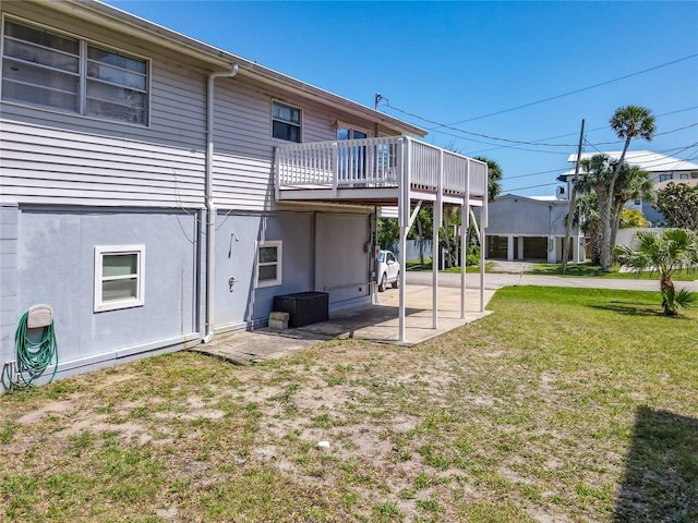 824 Garfish Ave, New Smyrna Beach, FL 32169 - rear view of house featuring a yard, a patio area, and a wooden deck