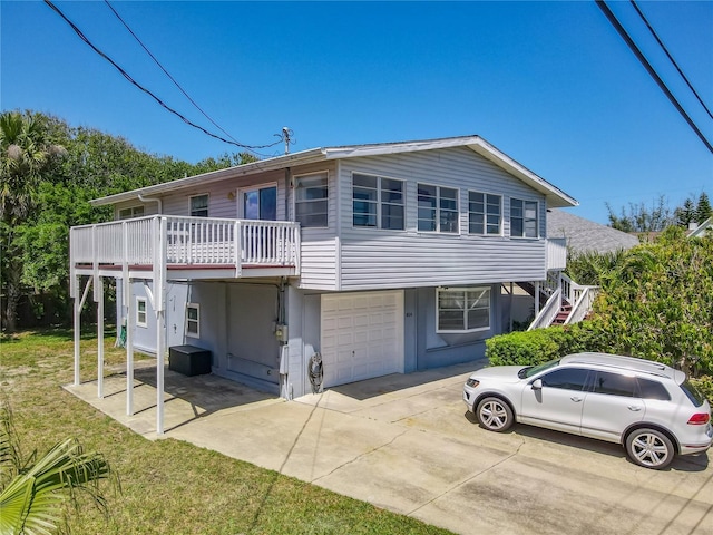 824 Garfish Ave, New Smyrna Beach, FL 32169 - view of front of home with a garage, driveway, a front yard, and stairway