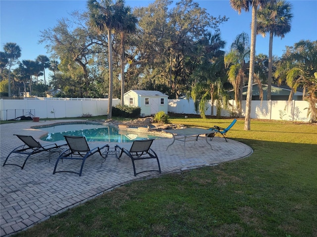 view of swimming pool featuring a storage unit, a patio area, and a yard