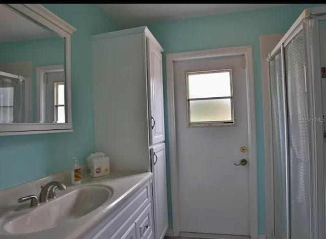 bathroom with vanity and a shower with shower door