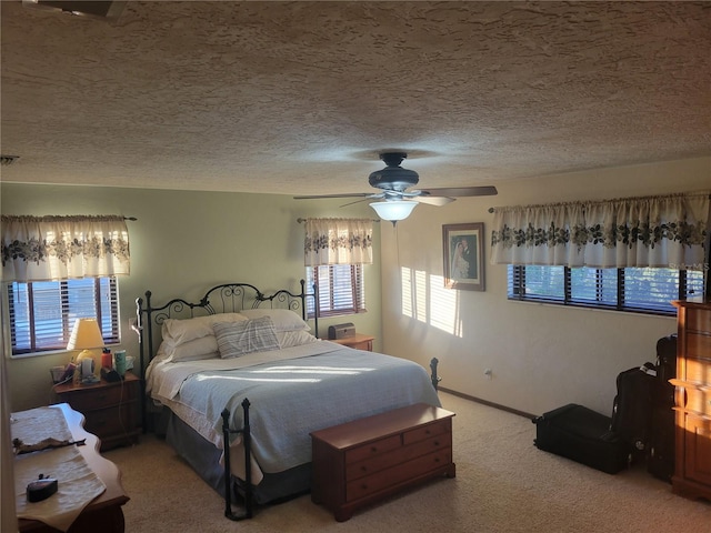 bedroom with a textured ceiling, carpet floors, and ceiling fan