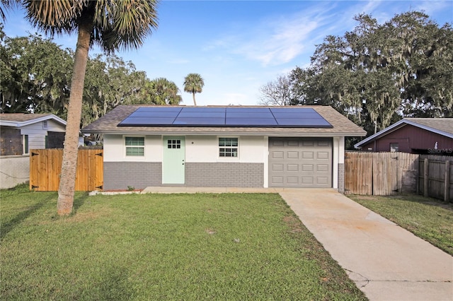 ranch-style home featuring solar panels and a front yard