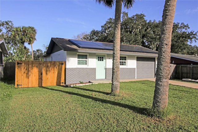 view of front of house with a front yard, solar panels, and a garage