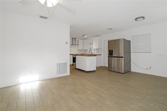 unfurnished living room with light hardwood / wood-style flooring, ceiling fan, and sink