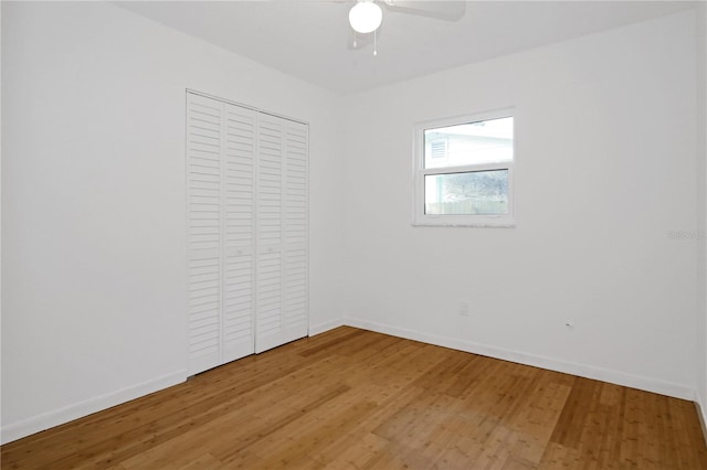 unfurnished bedroom with hardwood / wood-style floors, ceiling fan, and a closet