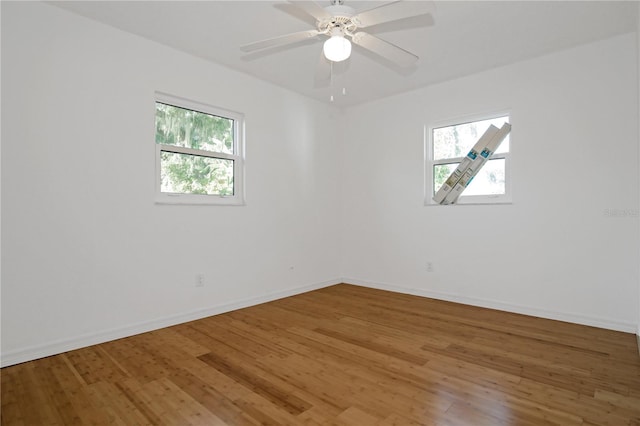 spare room featuring plenty of natural light, ceiling fan, and wood-type flooring