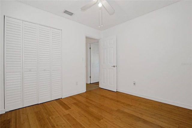 unfurnished bedroom featuring a closet, hardwood / wood-style flooring, and ceiling fan